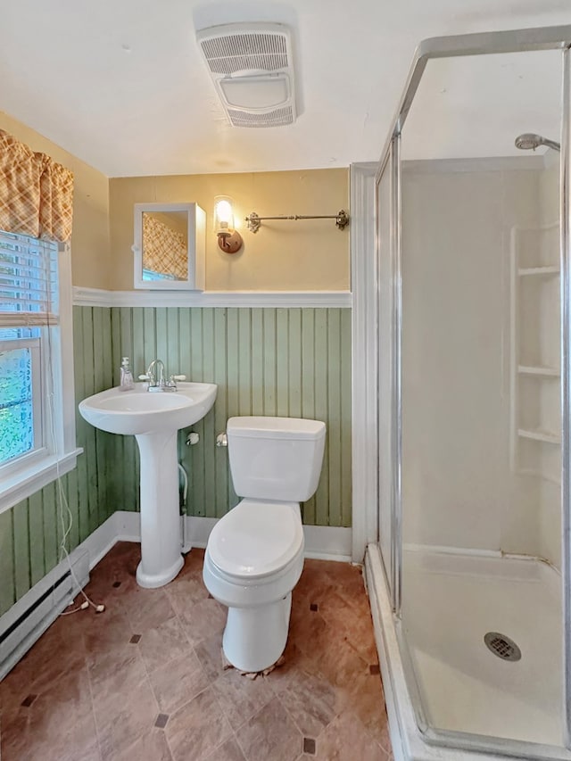 25539 Shoremain Dr, Bloxom, VA 23308 - bathroom with a stall shower, a baseboard heating unit, toilet, and a wainscoted wall