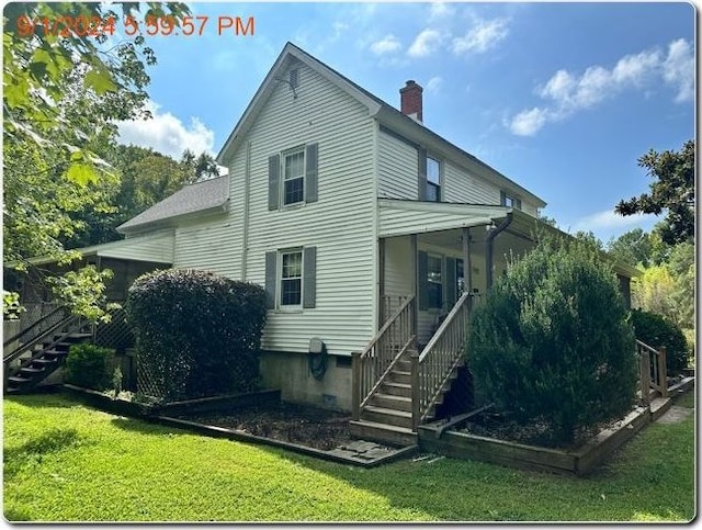 rear view of property with a yard and a porch