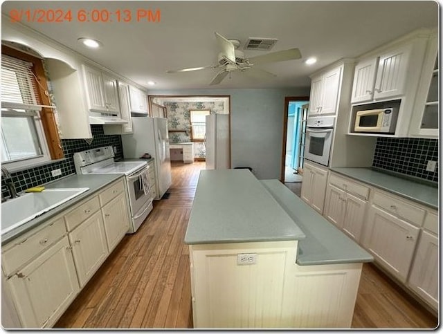 kitchen with white cabinets, white appliances, tasteful backsplash, and a kitchen island