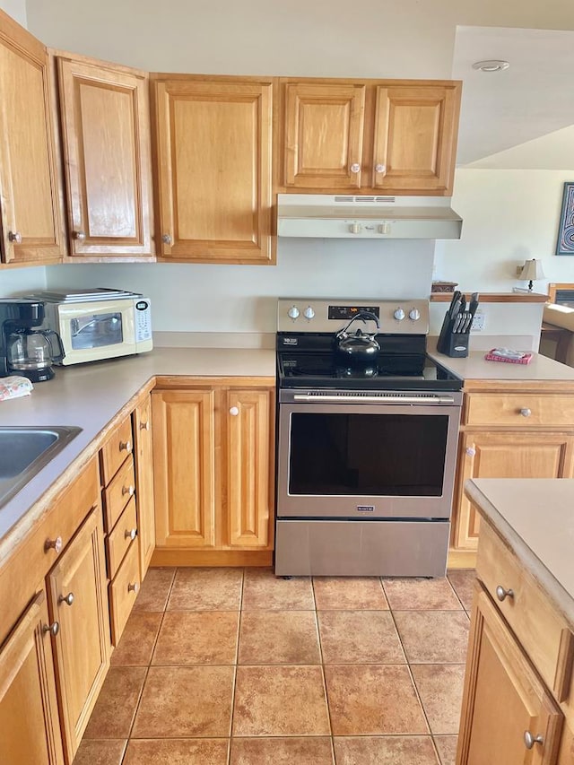 5108 Wildcat Ln, Chincoteague, VA 23336 - kitchen featuring stainless steel range with electric stovetop, under cabinet range hood, light countertops, and light tile patterned flooring
