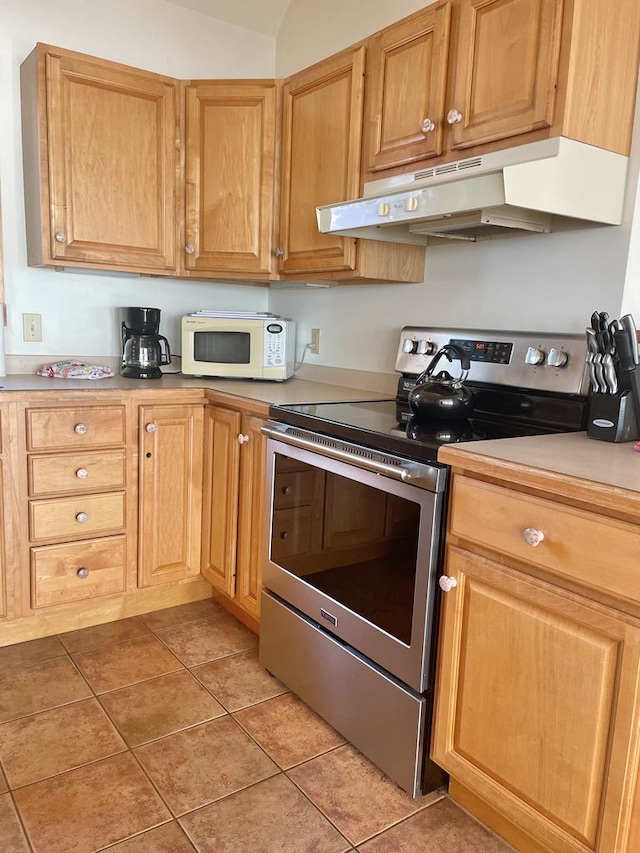 5108 Wildcat Ln, Chincoteague, VA 23336 - kitchen with electric stove, under cabinet range hood, white microwave, light tile patterned flooring, and light countertops