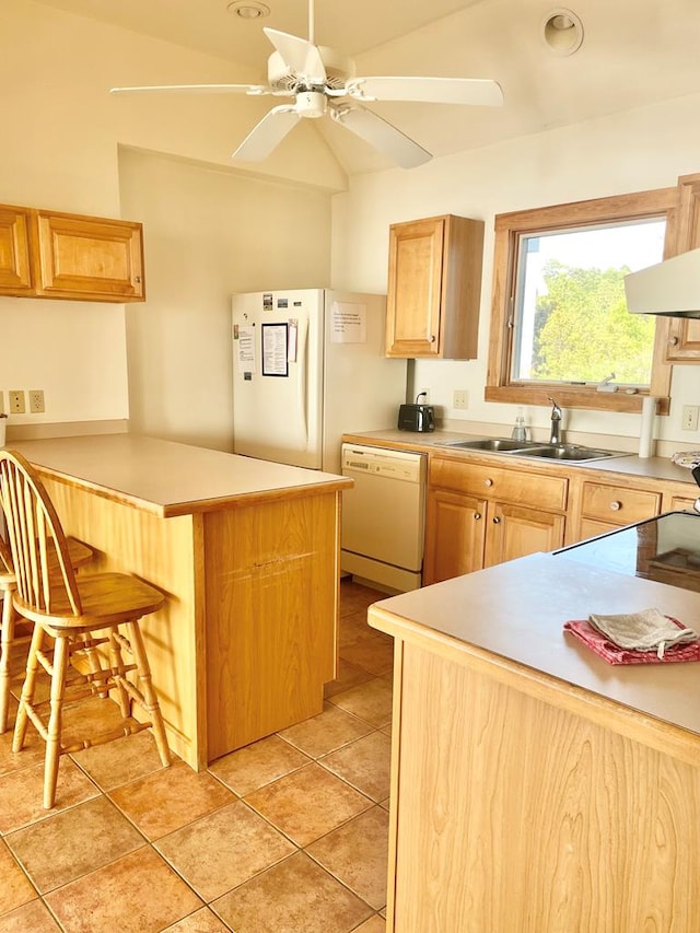 5108 Wildcat Ln, Chincoteague, VA 23336 - kitchen with white appliances, a kitchen bar, ceiling fan, a peninsula, and light brown cabinetry