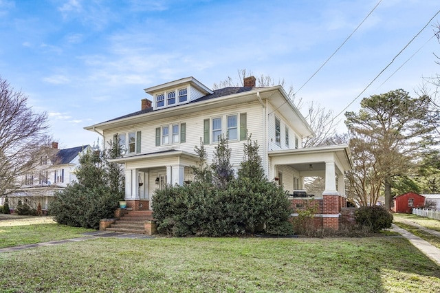 traditional style home with a front yard, covered porch, and a chimney