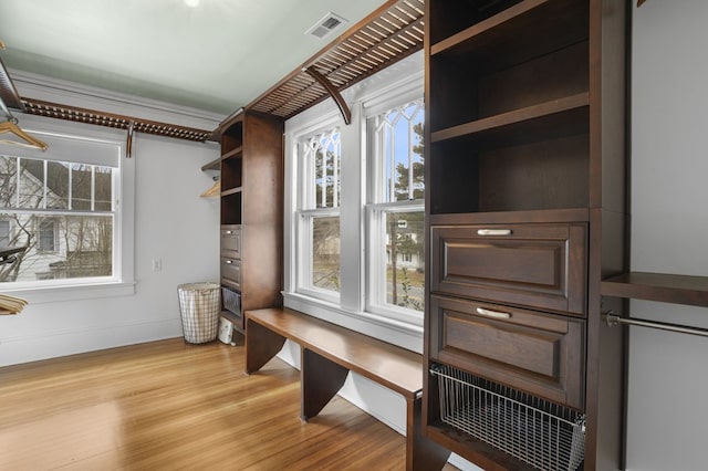 mudroom featuring baseboards, visible vents, and light wood finished floors