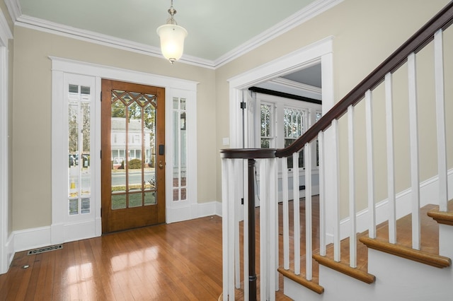 entrance foyer featuring stairway, visible vents, crown molding, and wood finished floors