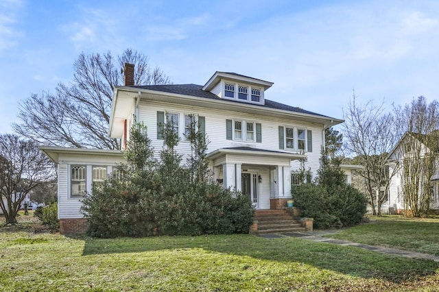 traditional style home with a chimney and a front yard