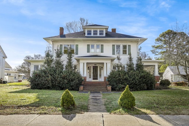 traditional style home with a chimney and a front yard