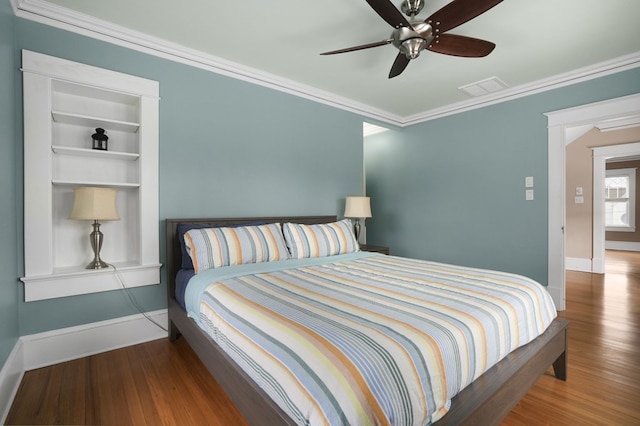 bedroom featuring wood finished floors, visible vents, and baseboards