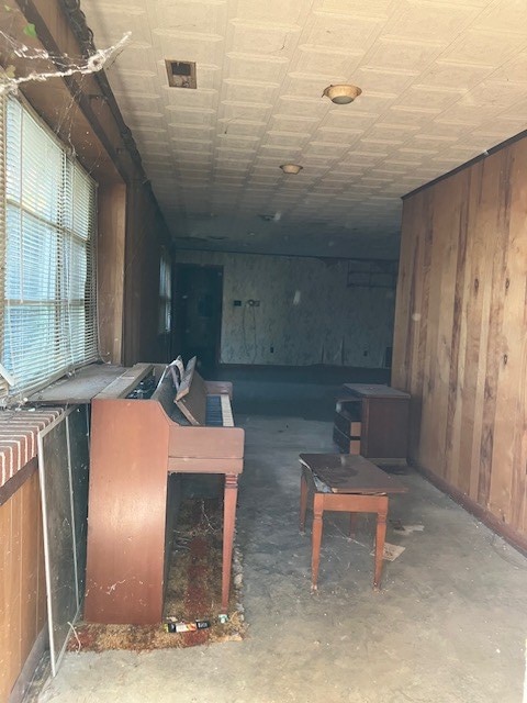 miscellaneous room featuring wooden walls and concrete floors