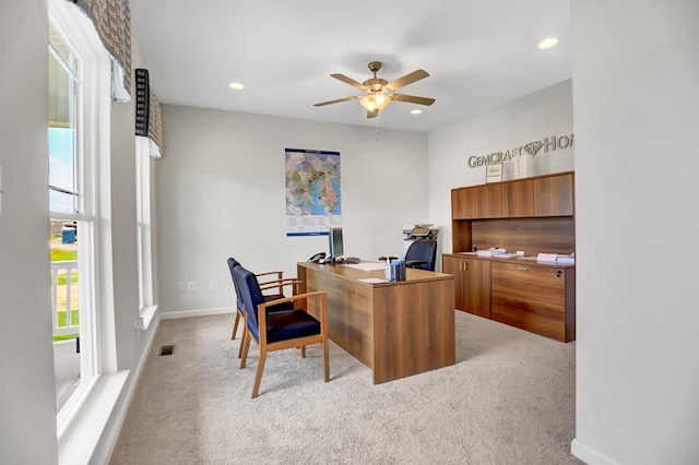 home office with light carpet, a wealth of natural light, and ceiling fan