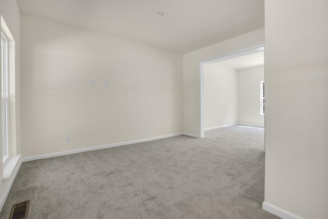 spare room featuring light carpet