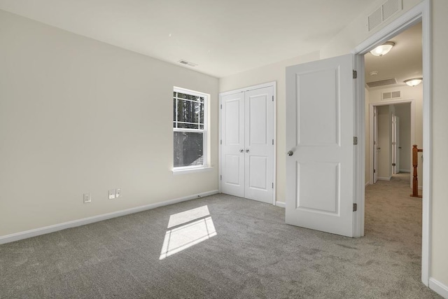 unfurnished bedroom featuring a closet and light colored carpet