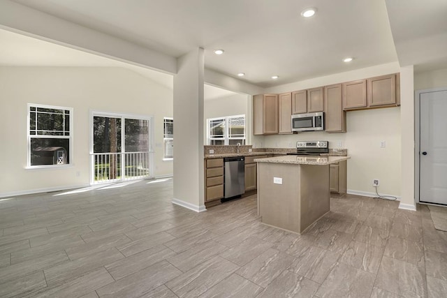 kitchen featuring vaulted ceiling, stainless steel appliances, a kitchen island, and light stone counters