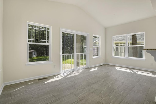 unfurnished room with vaulted ceiling