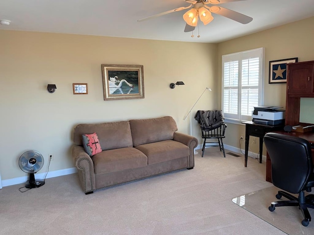 carpeted office space with baseboards and ceiling fan