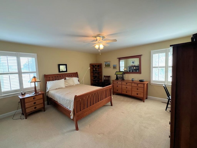 bedroom with light carpet, ceiling fan, and baseboards