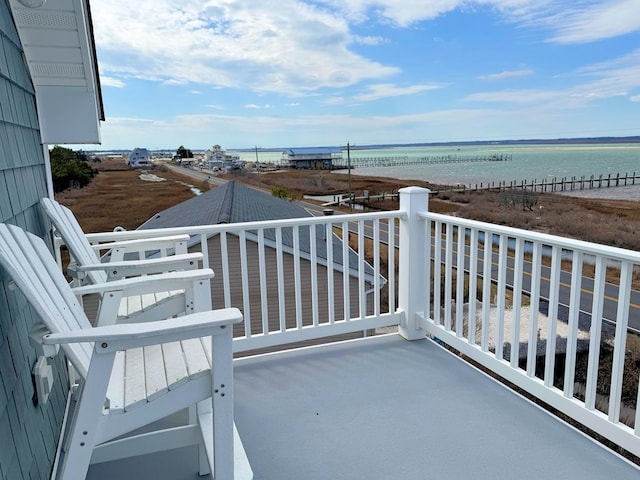 balcony featuring a view of the beach and a water view