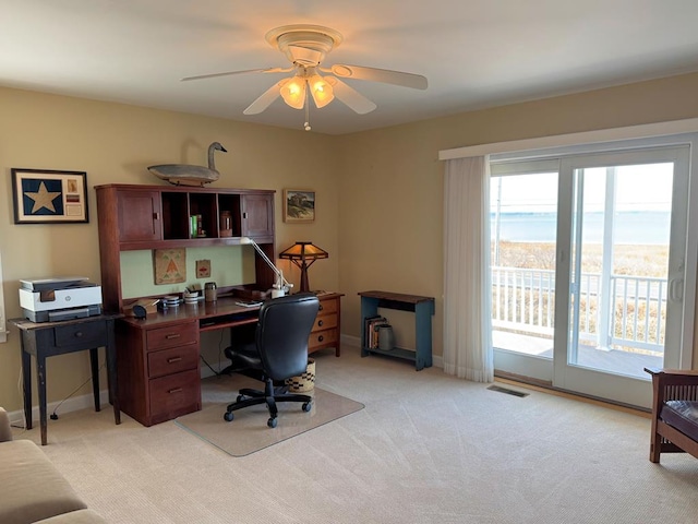 office area with visible vents, light colored carpet, baseboards, and ceiling fan