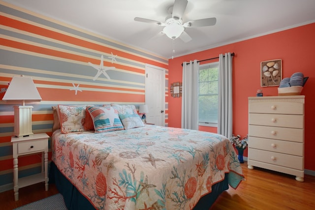 bedroom featuring wood-type flooring, ceiling fan, and crown molding