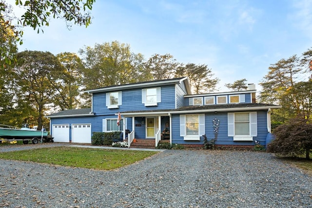 front of property featuring a front lawn, covered porch, and a garage