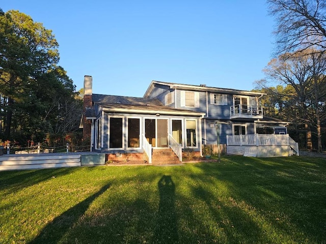 10388 Highland Ct, Exmore, VA 23350 - back of property with a chimney, a balcony, a sunroom, and a lawn