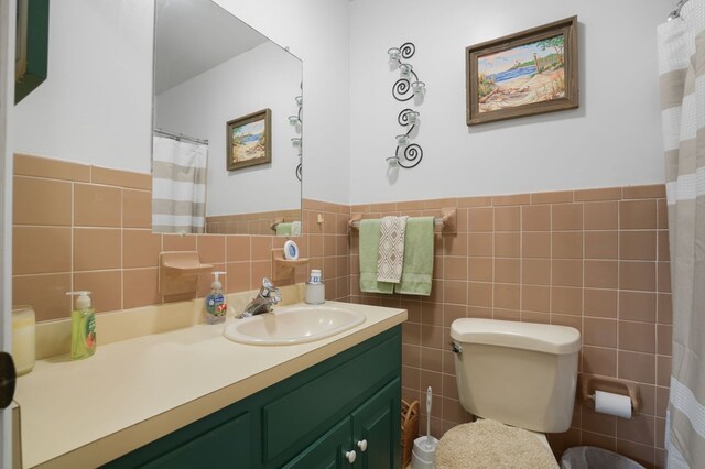 bathroom featuring vanity, toilet, and tile walls