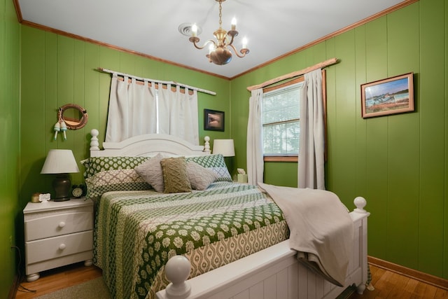 bedroom with a chandelier, wood-type flooring, and crown molding