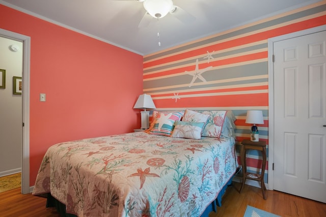 bedroom featuring hardwood / wood-style floors, ceiling fan, and ornamental molding