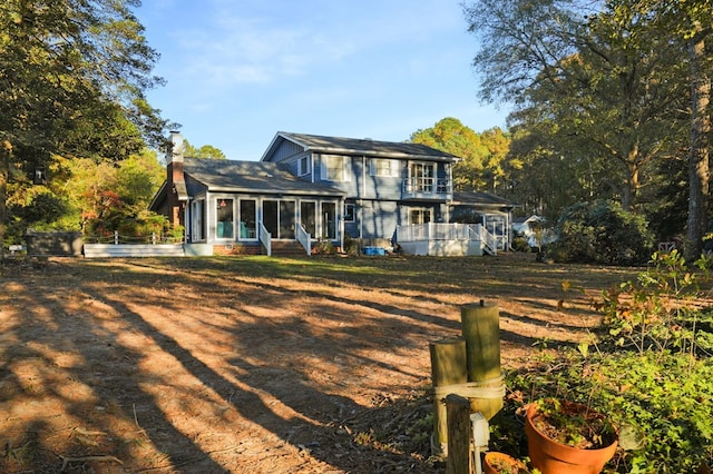 10388 Highland Ct, Exmore, VA 23350 - back of house featuring a sunroom, a shingled roof, and a chimney