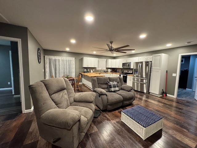 living room with ceiling fan, dark hardwood / wood-style flooring, and sink