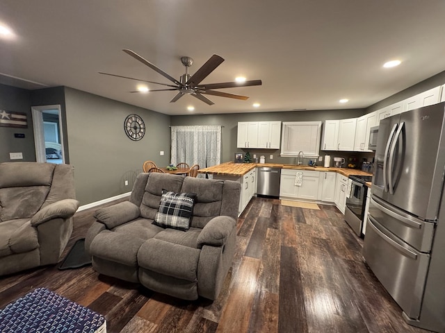 interior space featuring wood counters, sink, dark hardwood / wood-style flooring, white cabinetry, and stainless steel appliances