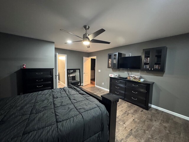 bedroom with dark hardwood / wood-style floors, ensuite bath, and ceiling fan