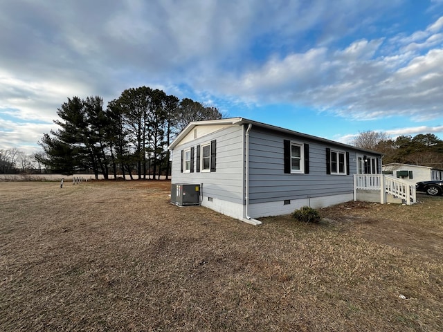 view of property exterior with central AC and a lawn