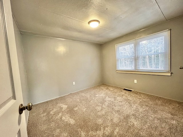 carpeted spare room with a textured ceiling