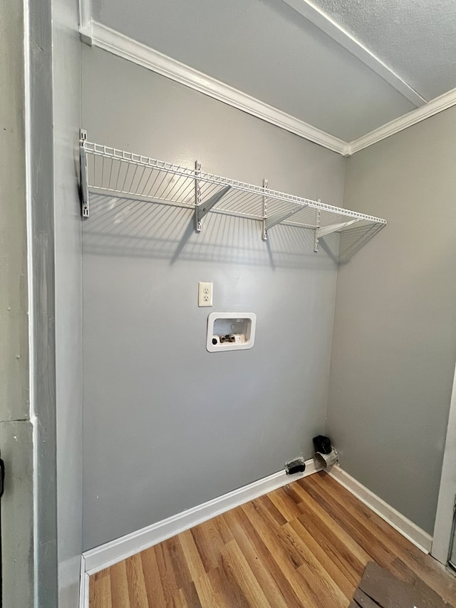 laundry room with ornamental molding, hookup for a washing machine, and hardwood / wood-style floors