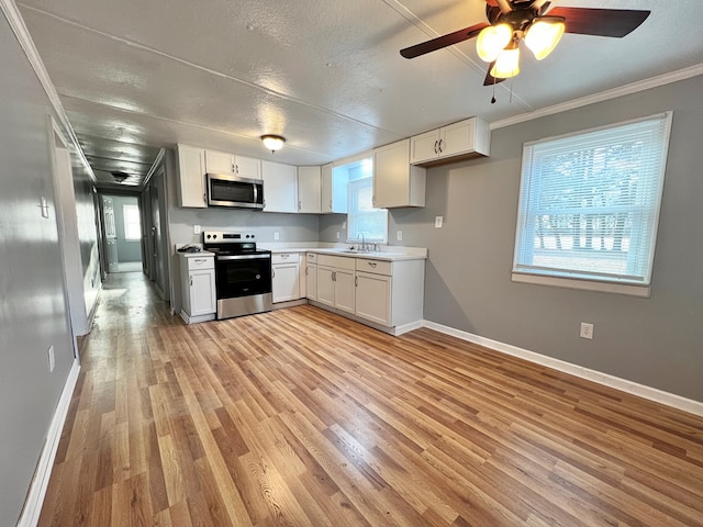 kitchen with sink, crown molding, light wood-type flooring, stainless steel appliances, and white cabinets