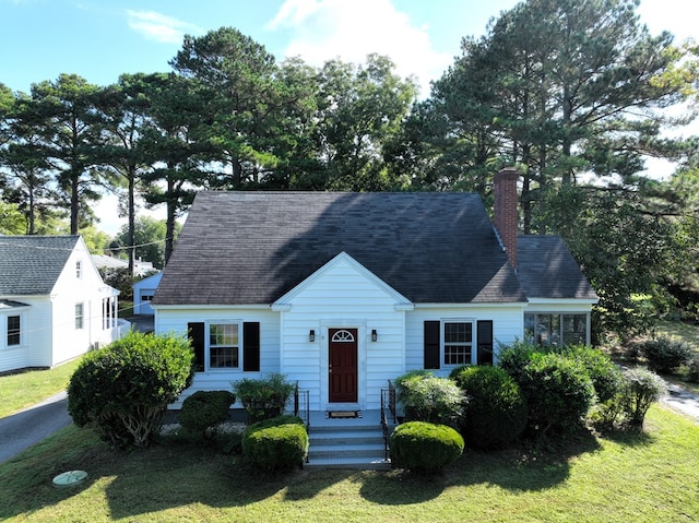 new england style home featuring a front yard