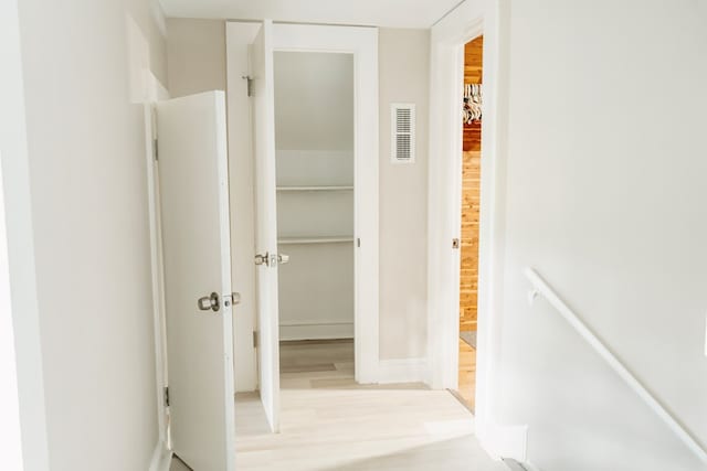 corridor with light hardwood / wood-style floors