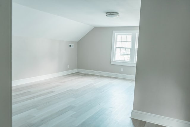 bonus room featuring light hardwood / wood-style floors and vaulted ceiling