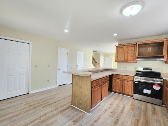 kitchen featuring kitchen peninsula, stainless steel stove, and light hardwood / wood-style flooring