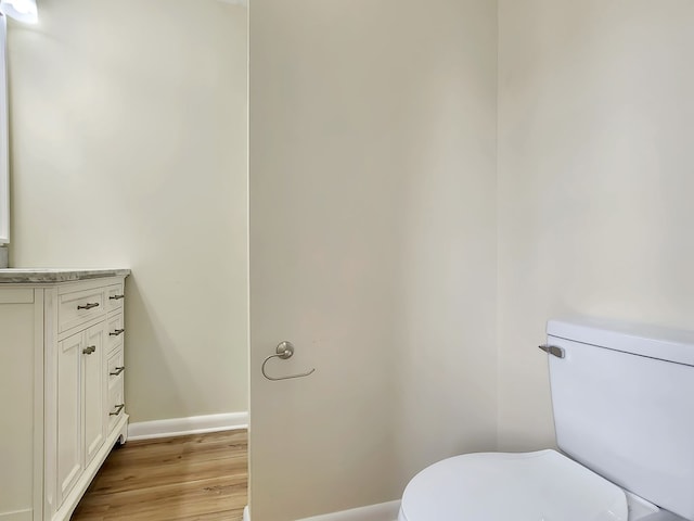 bathroom with hardwood / wood-style floors, vanity, and toilet