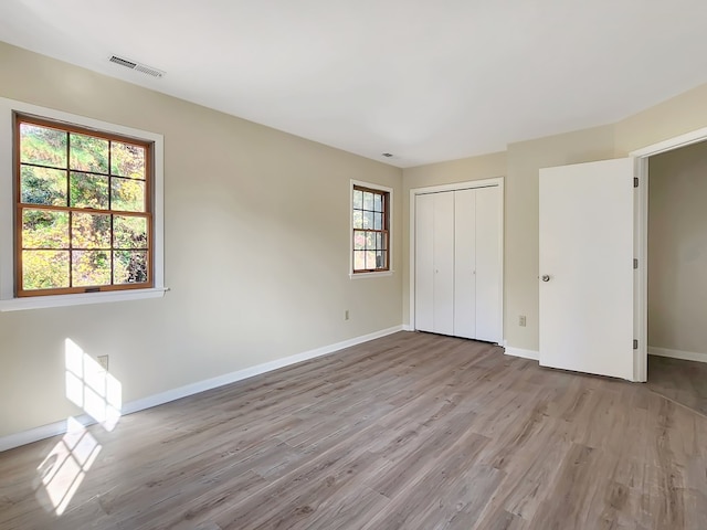 unfurnished bedroom featuring a closet and light hardwood / wood-style floors