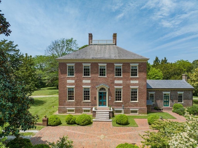 colonial inspired home with a front lawn