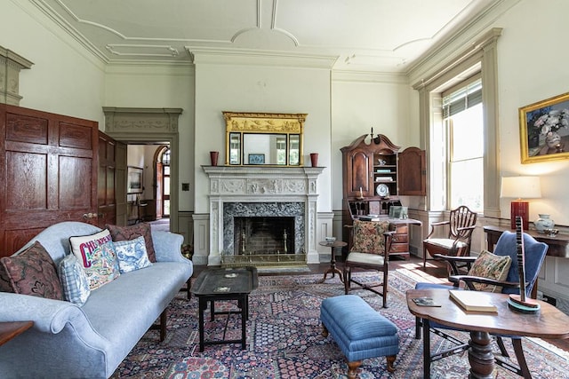 living room with a premium fireplace and crown molding