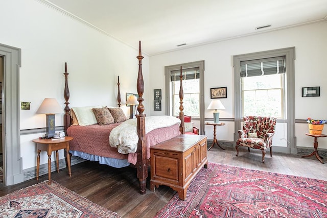 bedroom with dark hardwood / wood-style floors and ornamental molding