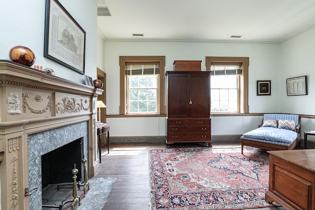 sitting room featuring light hardwood / wood-style floors, a premium fireplace, and crown molding