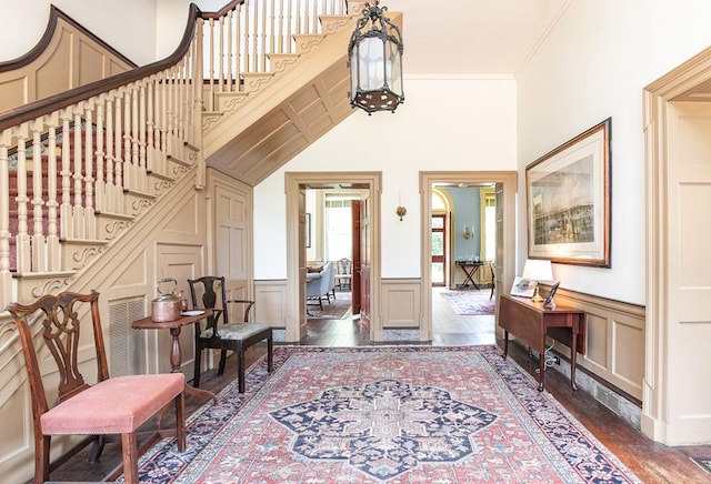 entryway with dark hardwood / wood-style flooring and ornamental molding