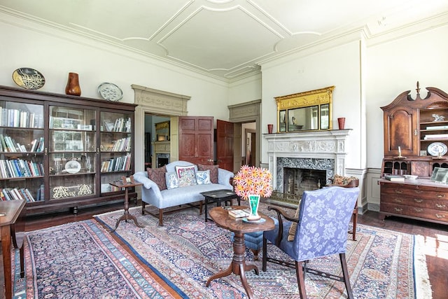 living room with crown molding, a fireplace, and dark wood-type flooring