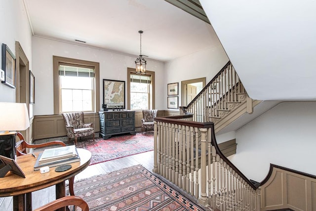 interior space featuring crown molding, wood-type flooring, and an inviting chandelier