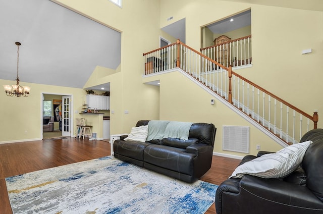 37323 Davey Jones Blvd, Greenbackville, VA 23356 - living room featuring a high ceiling, wood finished floors, a chandelier, stairs, and baseboards